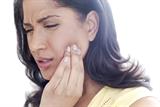 Woman holding face in pain